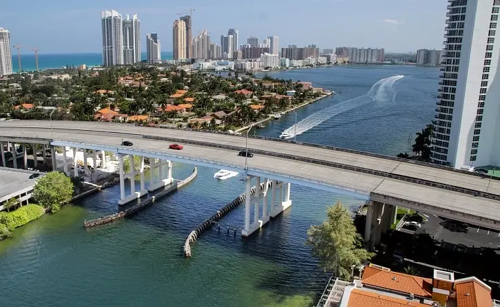 A scenic view of Miami Beach with high-rise buildings, waterfront homes, and a bridge, showcasing Florida’s appeal for foreign homebuyers.