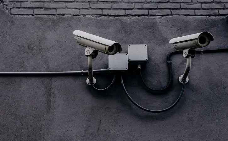 A pair of CCTV surveillance cameras mounted on a wall, representing security and monitoring.