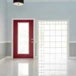 A bright interior of a Florida home with glossy tile flooring, a red door, and a glass block wall.