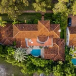 Overhead shot of upscale houses in Florida with terracotta roofs and backyard pools.