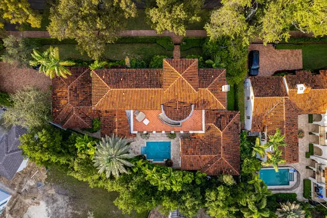 Overhead shot of upscale houses in Florida with terracotta roofs and backyard pools.
